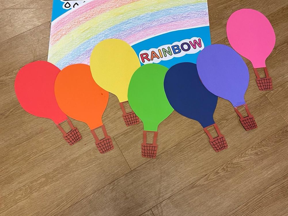 Cartellone con arcobaleno e mongolfiere colorate del progetto di inglese